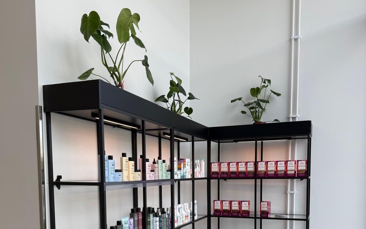 Produkthylla med hårvårdsprodukter och gröna växter